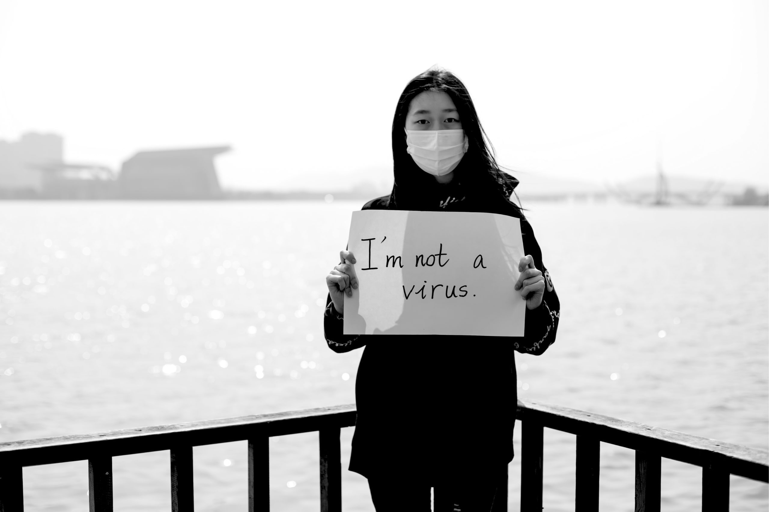 Masked Asian woman holds I Am Not A Virus sign